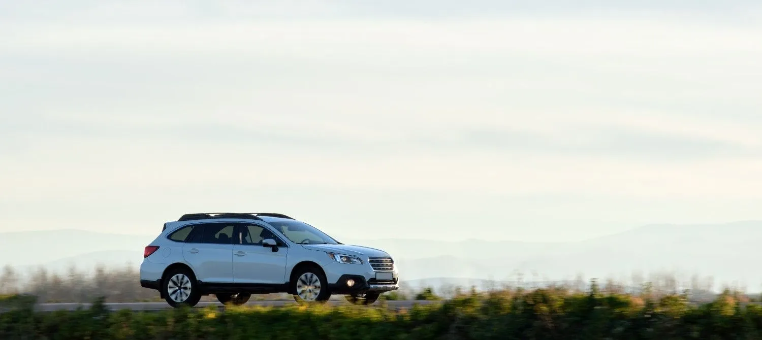 Driver reviewing auto insurance choices beside a car